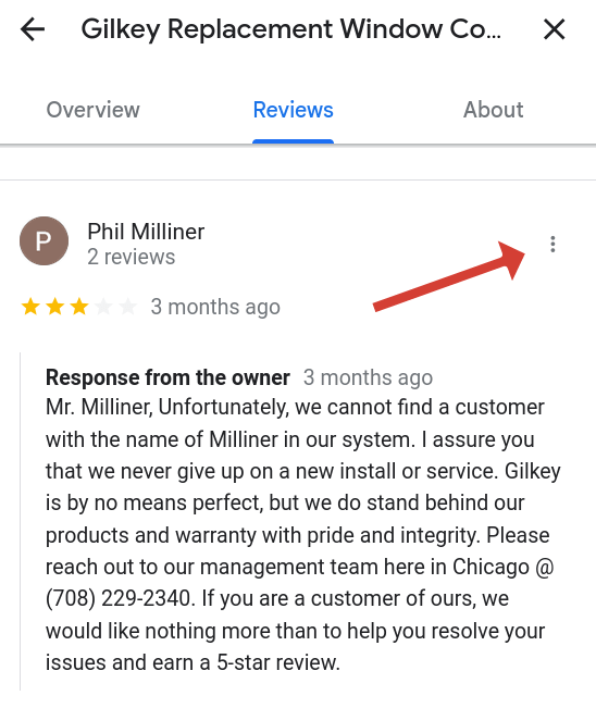 Image showing a review on a Google Business profile with an arrow pointing at the location of the 3 dots to report it.